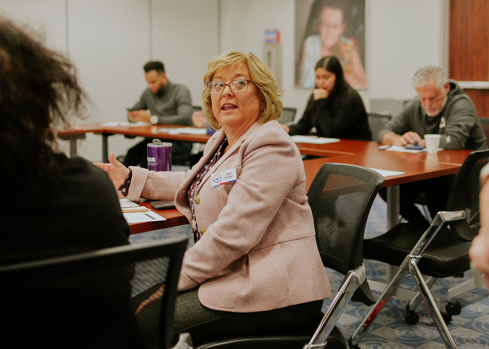 A participant speaking and gesturing during a small group conversation
