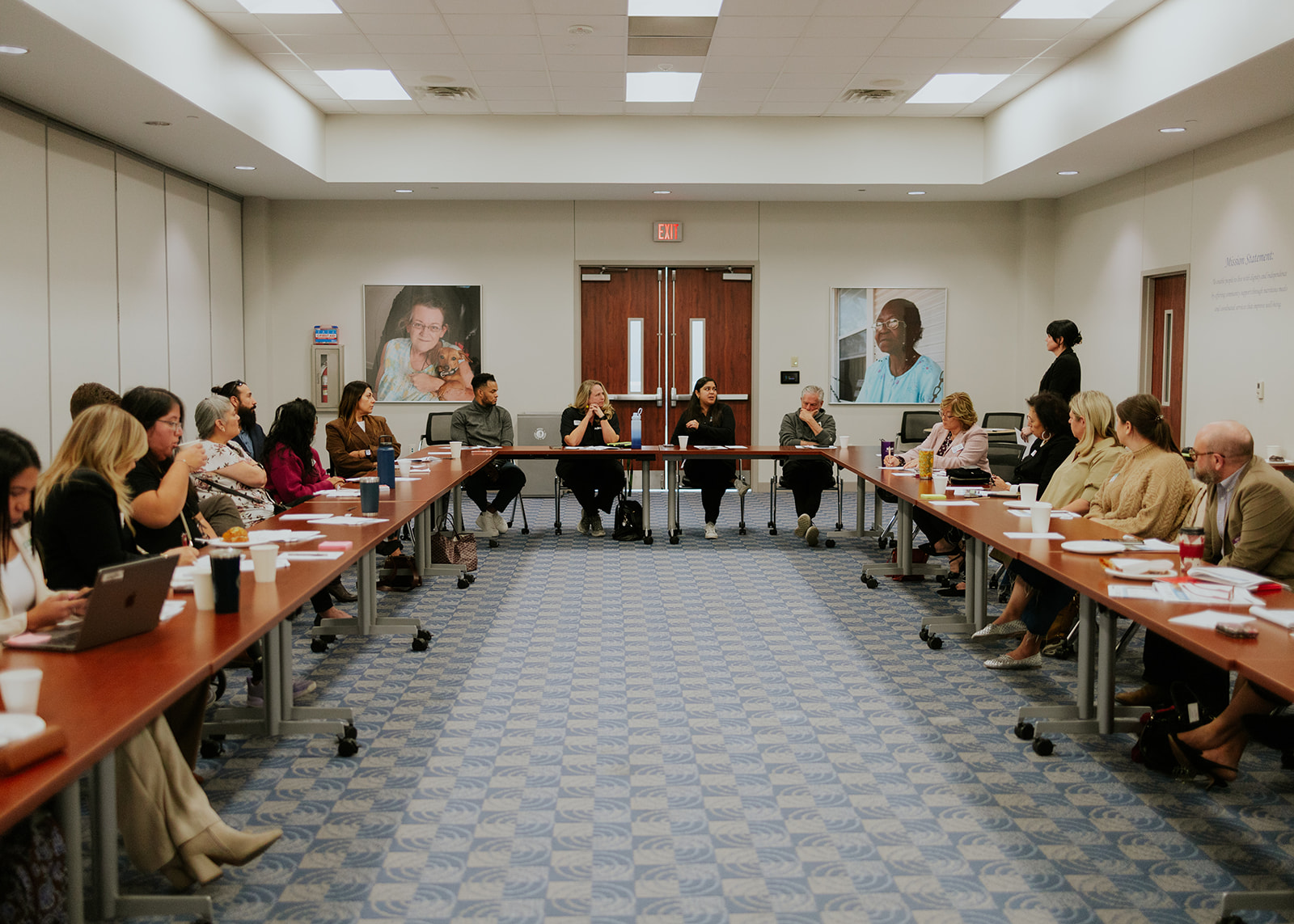 Nonprofit professionals gathered around a U-shaped table at a Roots to Leadership community meeting
