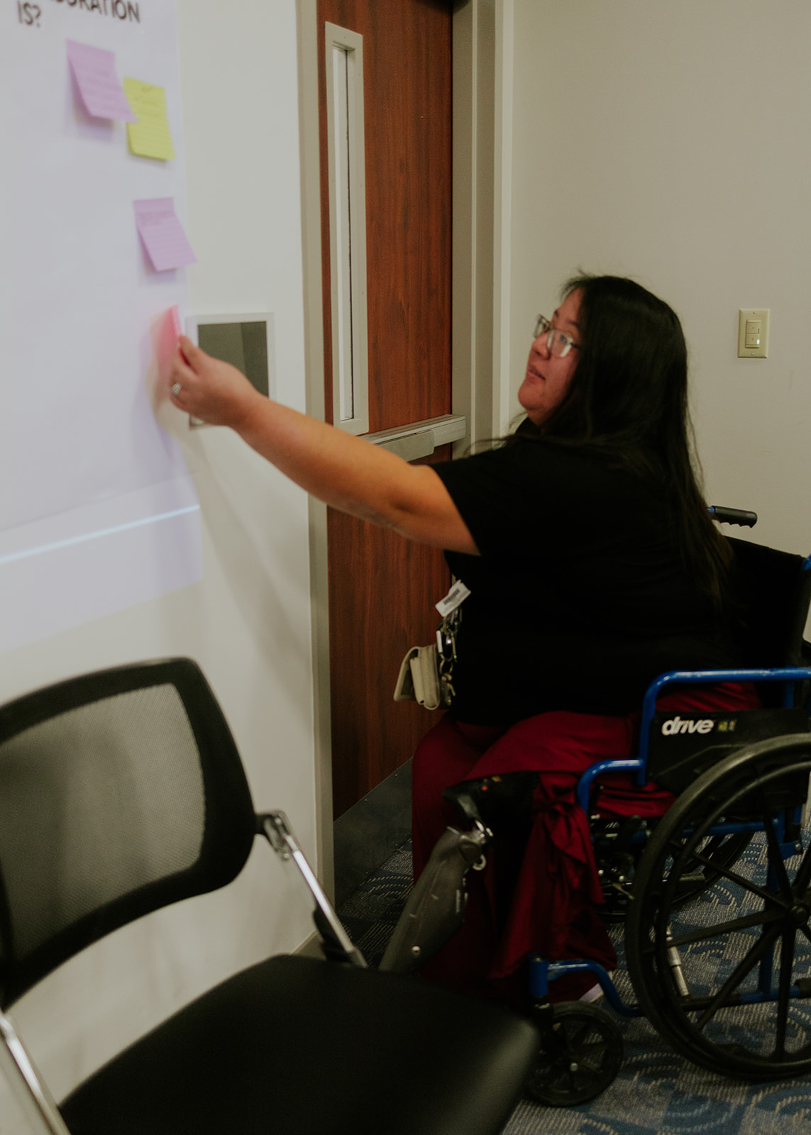 A participant adding a sticky note to a workshop board